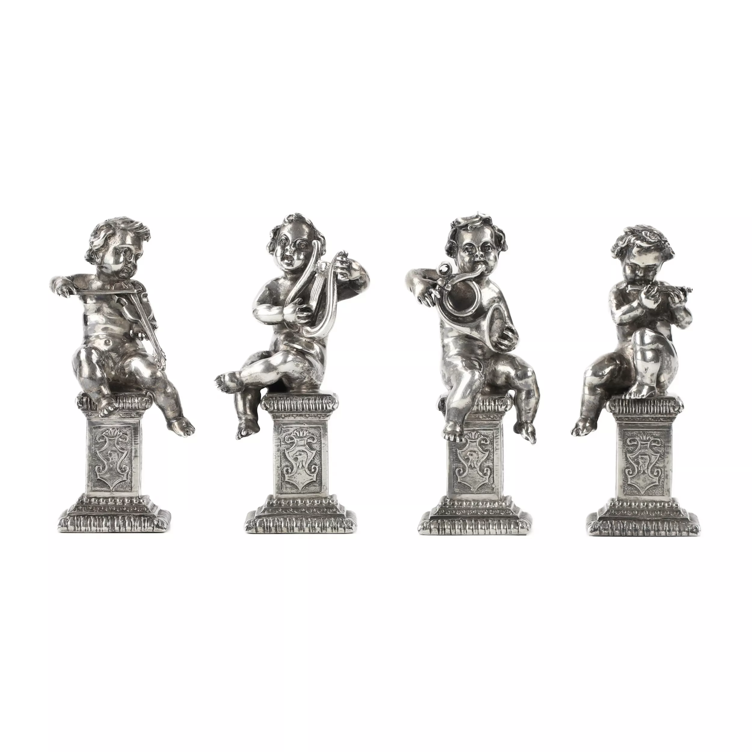 Quatre drôles de figures de musiciens putti en argent. 