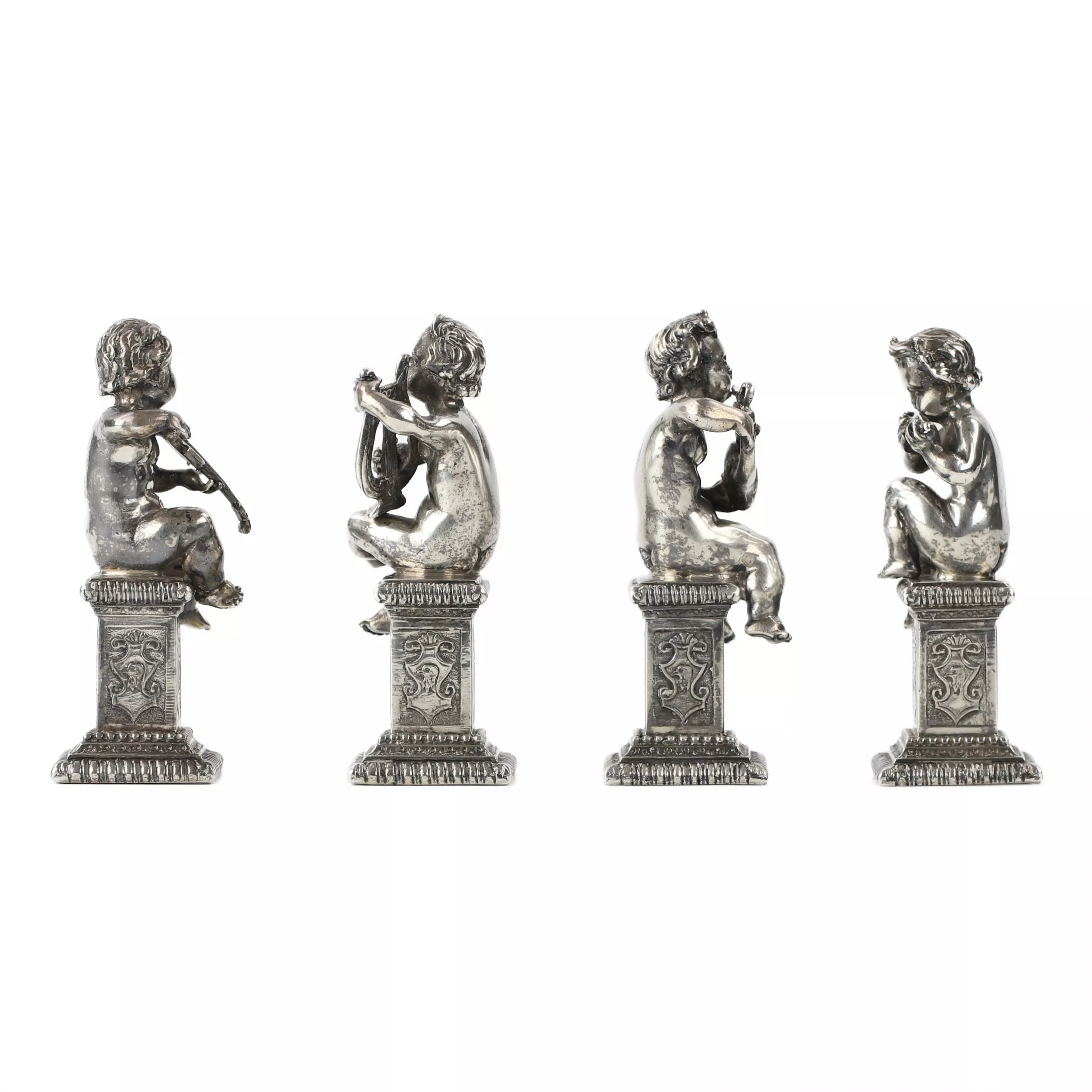 Quatre drôles de figures de musiciens putti en argent. 