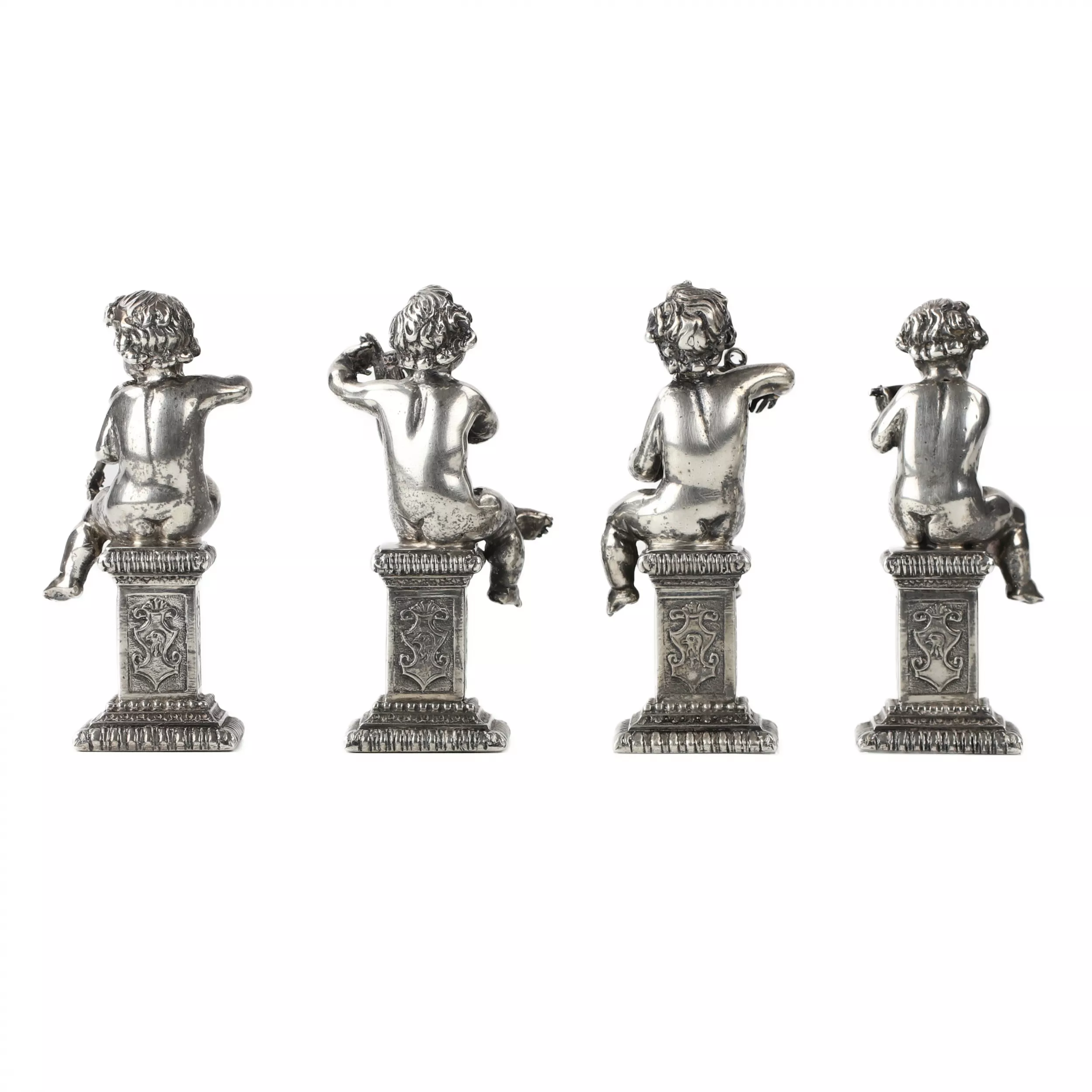 Quatre drôles de figures de musiciens putti en argent. 