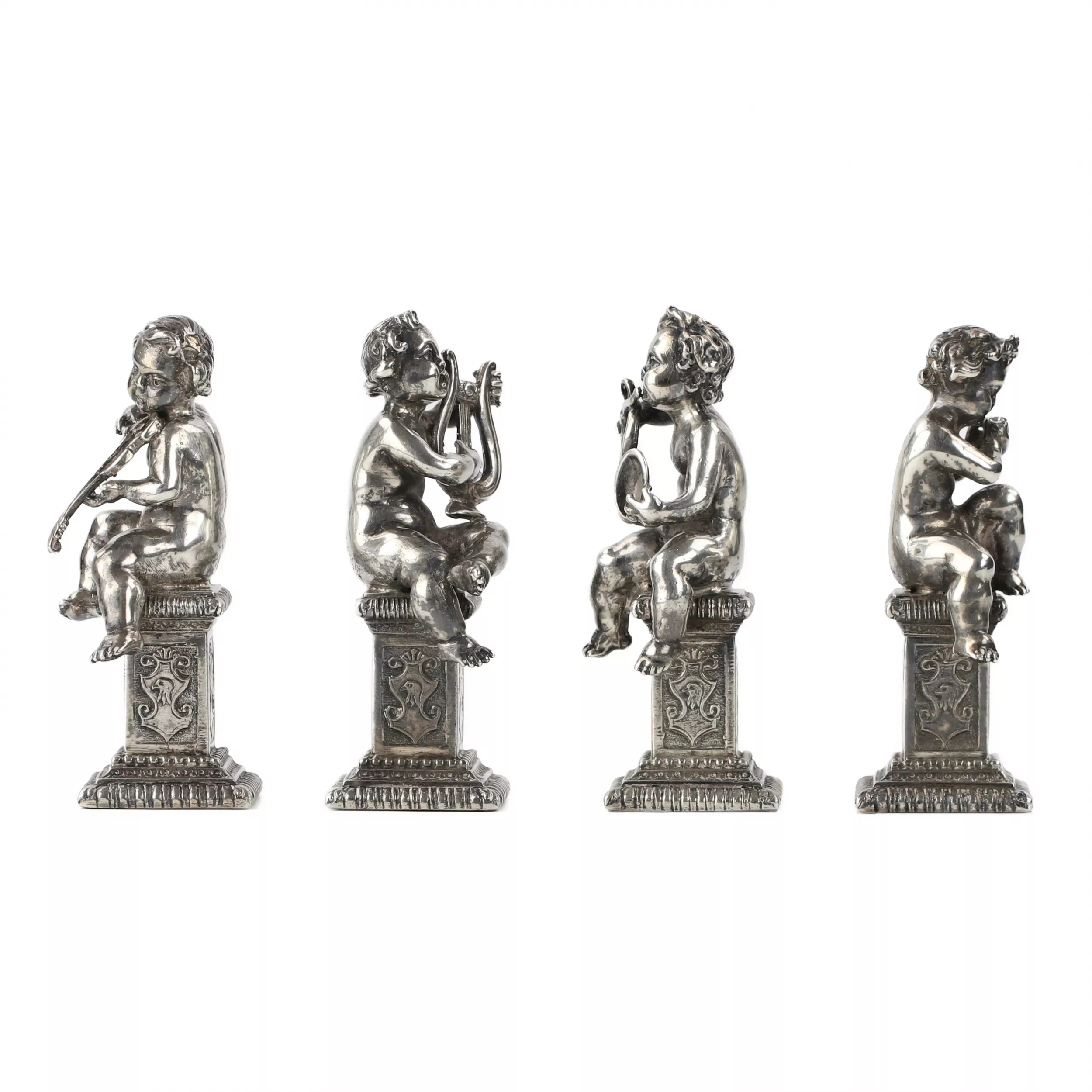 Quatre drôles de figures de musiciens putti en argent. 