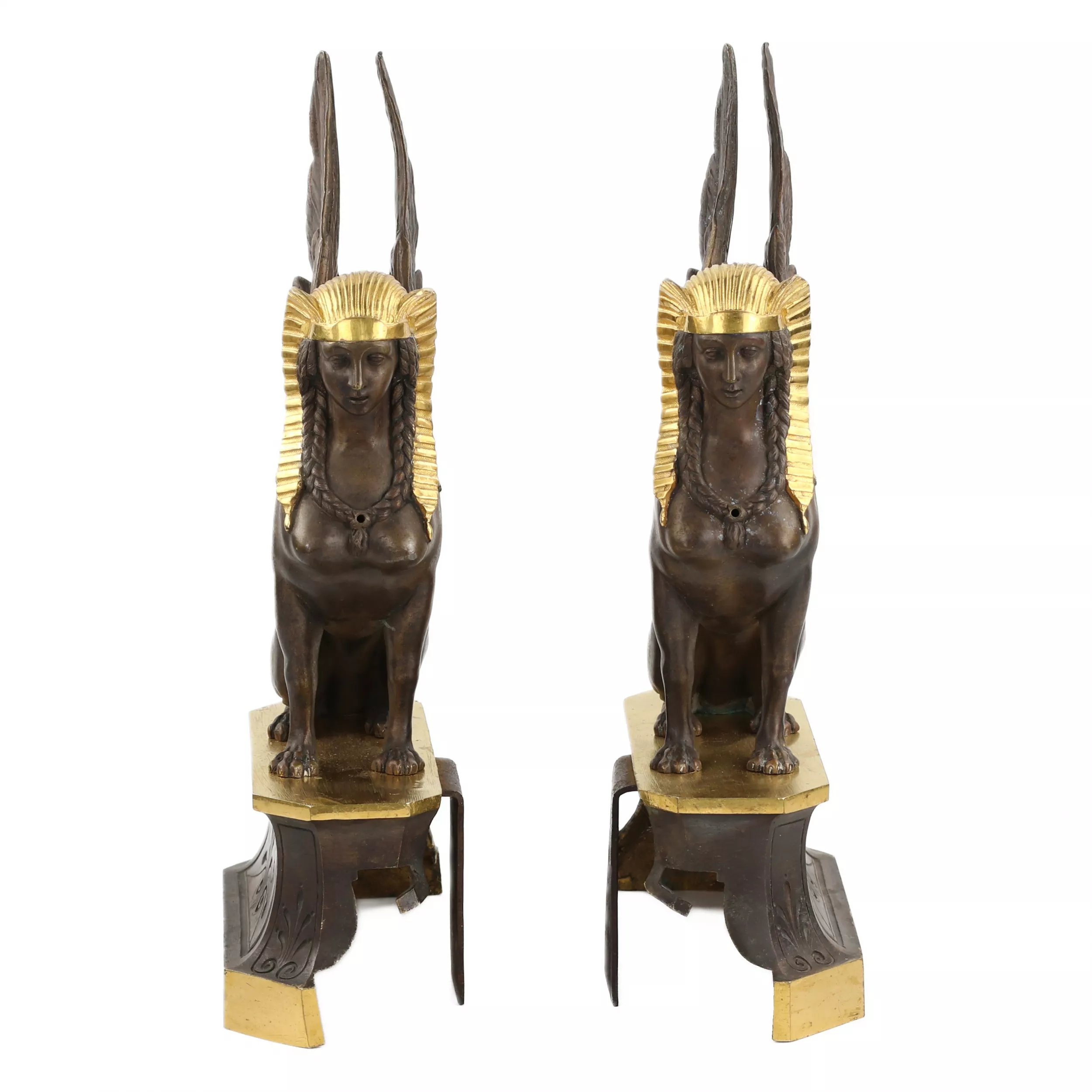 Une paire de bûchers en bronze patiné et doré se présente en forme de sphinx ailés. 19ème siècle. 