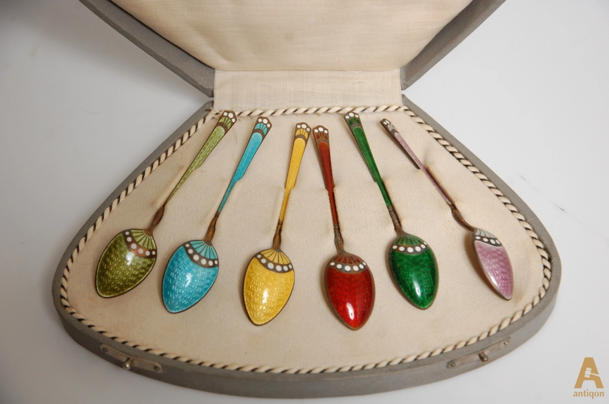 A set of silver spoons with enamel