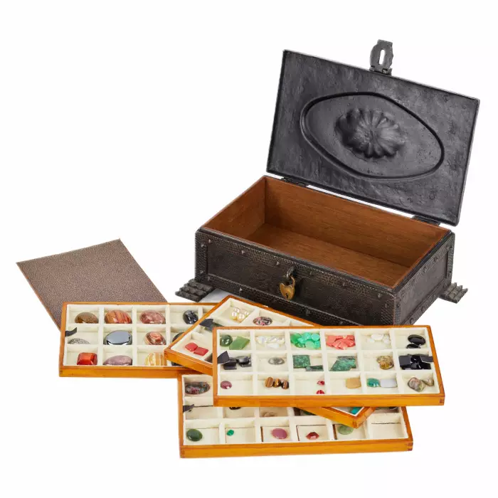 A large collection of semi-precious stones in a wrought-iron case