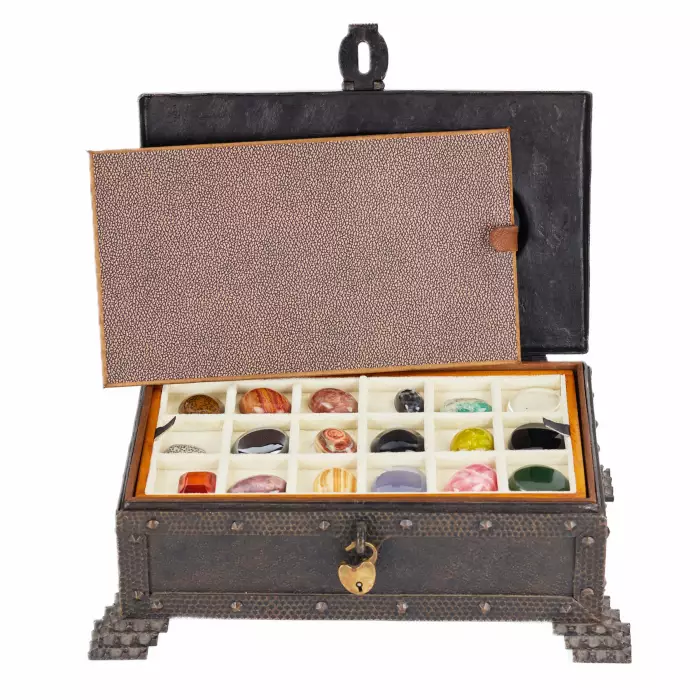 A large collection of semi-precious stones in a wrought-iron case