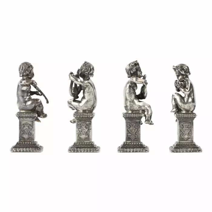 Quatre drôles de figures de musiciens putti en argent. 