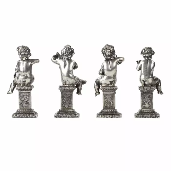 Quatre drôles de figures de musiciens putti en argent. 