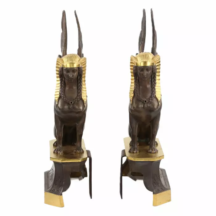 Une paire de bûchers en bronze patiné et doré se présente en forme de sphinx ailés. 19ème siècle. 