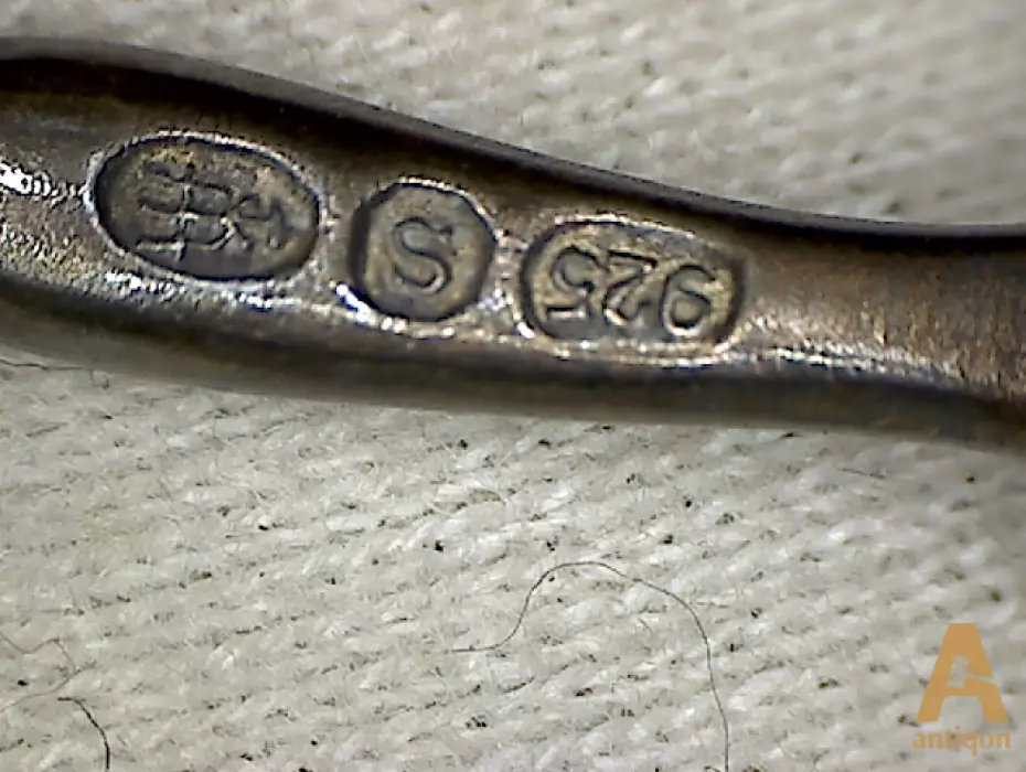 A set of silver spoons with enamel