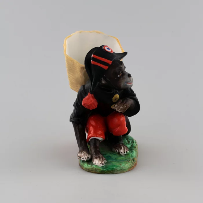 PORCELAIN FIGURE-CONTAINER MONKEY AS NAPOLEON. THURINGIA, GERMANY. LATE 19TH TO EARLY 20TH CENTURY.