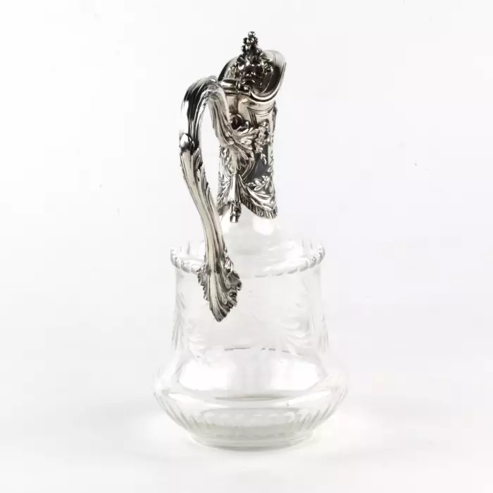 Une cruche à vin, un verre avec de largent. 