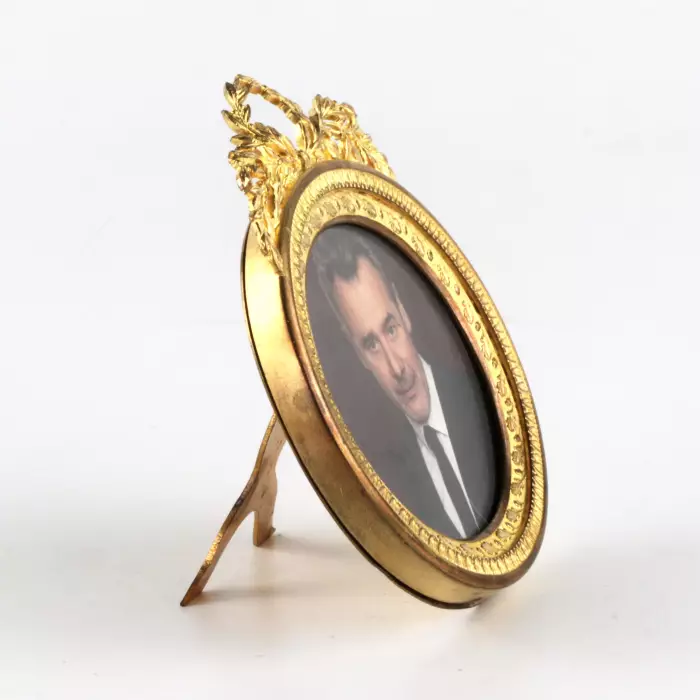 Round photo frame with empire decor. 