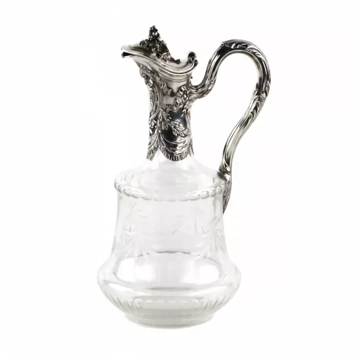 Une cruche à vin, un verre avec de largent. 