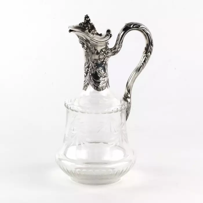 Une cruche à vin, un verre avec de largent. 