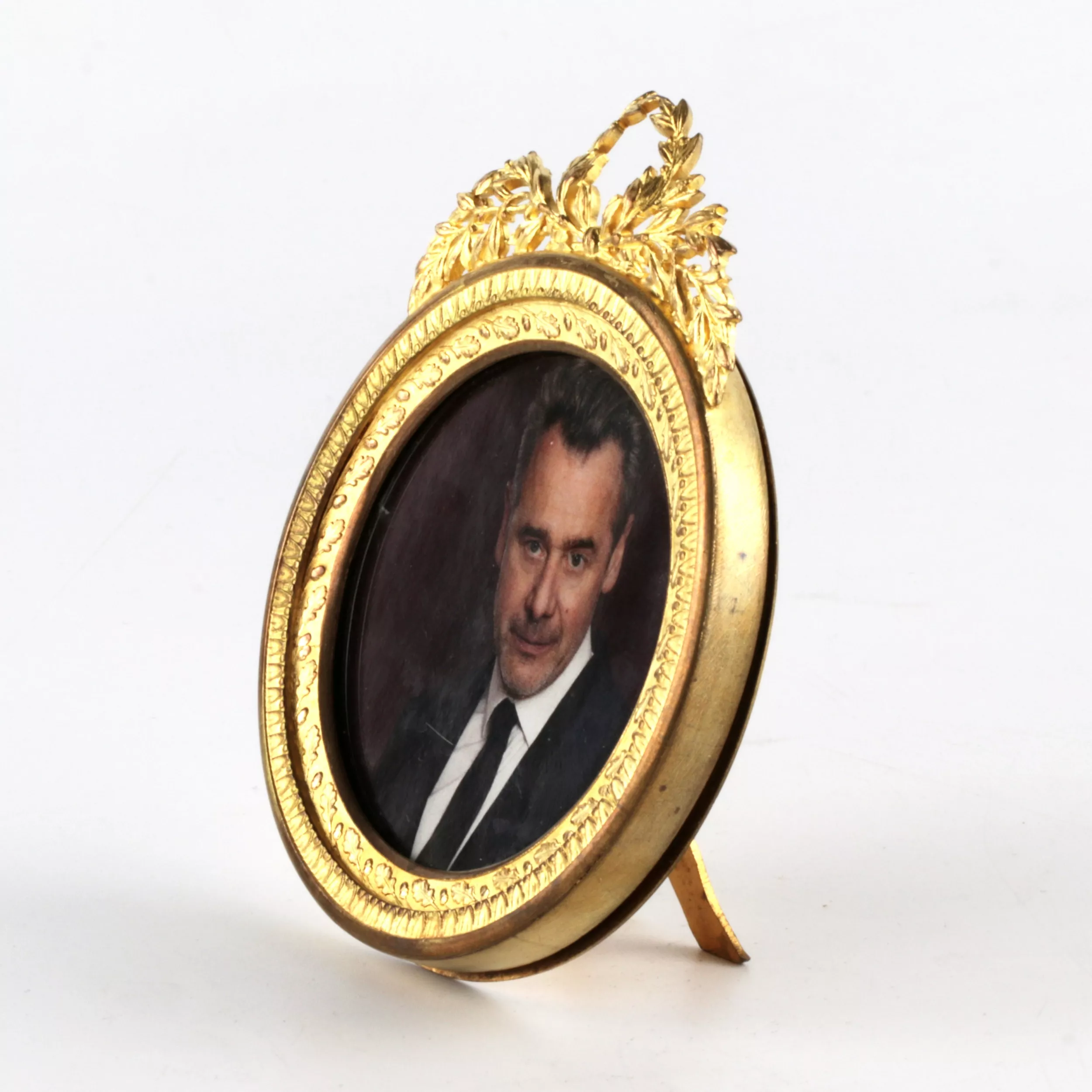 Round photo frame with empire decor. 