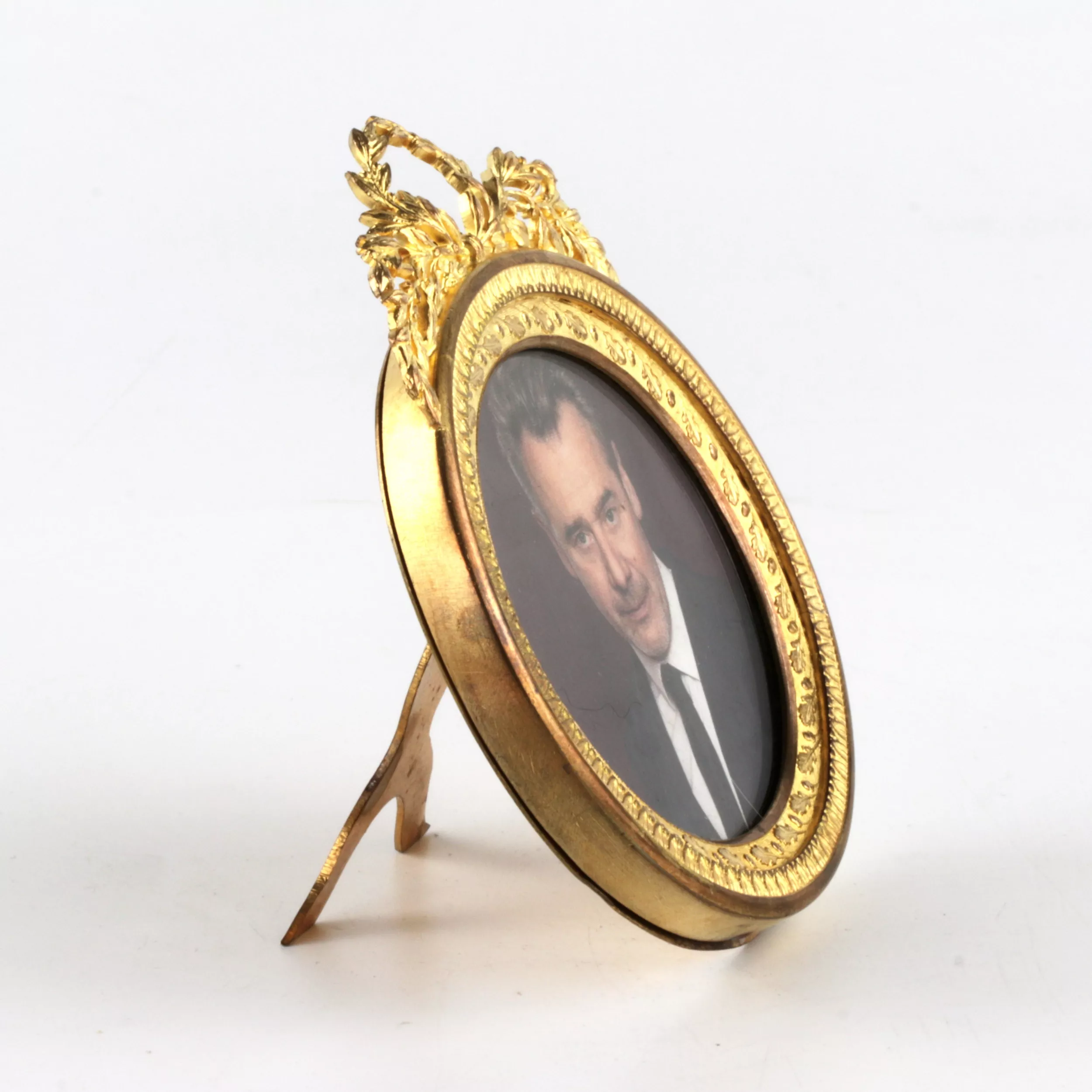 Round photo frame with empire decor. 