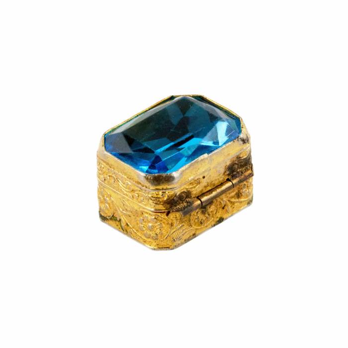 Pill box of gilded metal, with a large blue stone on the lid. Early 20th century. 