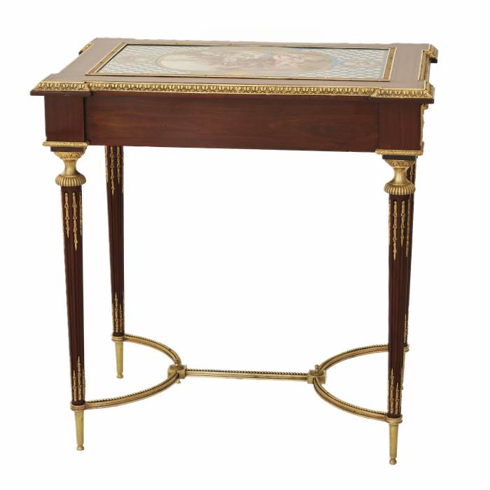 Une magnifique table de dame à decor de bronze dore et panneaux de porcelaine dans le goût d`Adam Weisweiler. France. XIXe siècle 