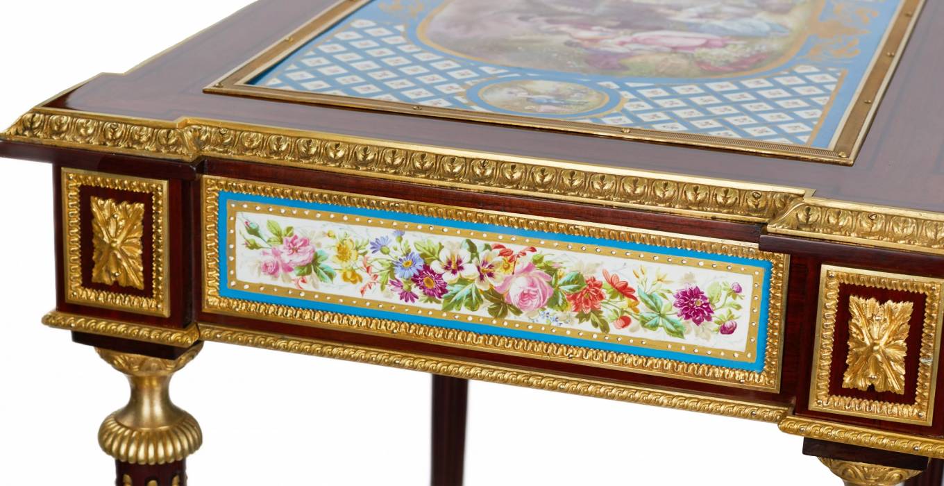 Une magnifique table de dame à decor de bronze dore et panneaux de porcelaine dans le goût d`Adam Weisweiler. France. XIXe siècle 