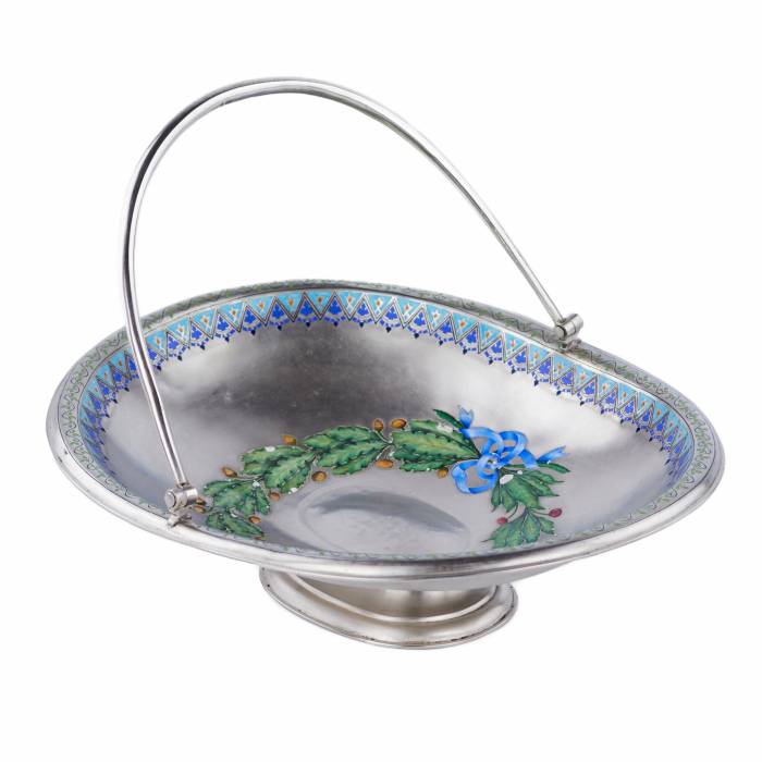 SUDRABA KONFEKŠU TRAUCIŅŠ AR KRĀSOTU EMALJU, KRIEVIJA, 1888. GADS Elegants sudraba konfekšu trauciņš uz apaļas pamatnes ar pārvietojamu, noapaļota šķērsgriezuma rokturi. Iekšpusi rotā apgleznots ozola un lauru lapu vainags, kas savīts ar zilu lent