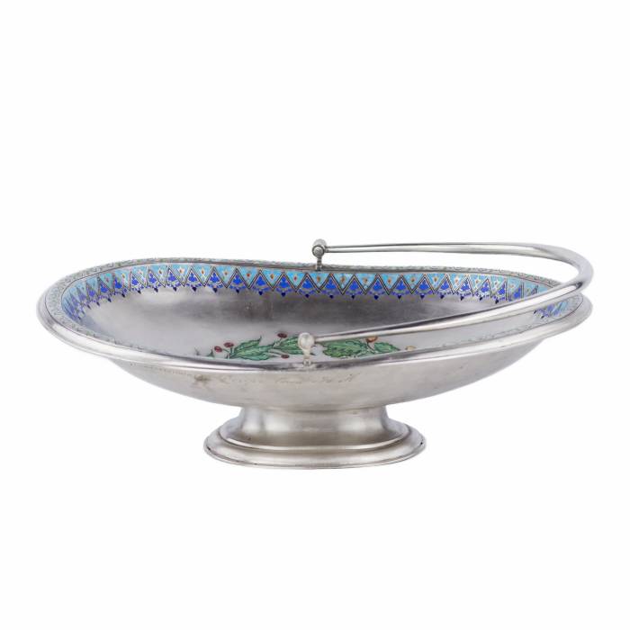 SUDRABA KONFEKŠU TRAUCIŅŠ AR KRĀSOTU EMALJU, KRIEVIJA, 1888. GADS Elegants sudraba konfekšu trauciņš uz apaļas pamatnes ar pārvietojamu, noapaļota šķērsgriezuma rokturi. Iekšpusi rotā apgleznots ozola un lauru lapu vainags, kas savīts ar zilu lent