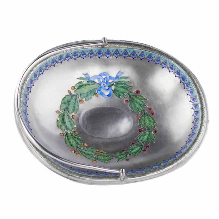 SUDRABA KONFEKŠU TRAUCIŅŠ AR KRĀSOTU EMALJU, KRIEVIJA, 1888. GADS Elegants sudraba konfekšu trauciņš uz apaļas pamatnes ar pārvietojamu, noapaļota šķērsgriezuma rokturi. Iekšpusi rotā apgleznots ozola un lauru lapu vainags, kas savīts ar zilu lent