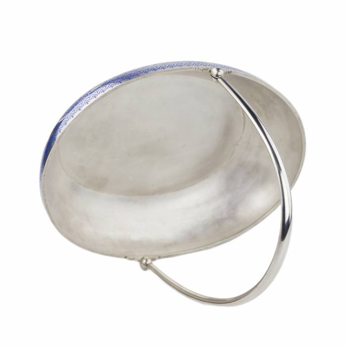 Sudraba augļu grozs ar šamplevē emalju. Pāvela Ovčiņņikova firma, Maskava, 1892. Ovāls sudraba augļu grozs ar augstu, kustīgu rokturi, kas izgatavots Pāvela Ovčiņņikova, imperatora galma piegādātāja, darbnīcā. Grozu rotā izsmalcināta kobalta zila 