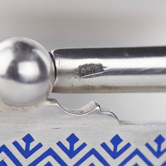 Sudraba augļu grozs ar šamplevē emalju. Pāvela Ovčiņņikova firma, Maskava, 1892. Ovāls sudraba augļu grozs ar augstu, kustīgu rokturi, kas izgatavots Pāvela Ovčiņņikova, imperatora galma piegādātāja, darbnīcā. Grozu rotā izsmalcināta kobalta zila 