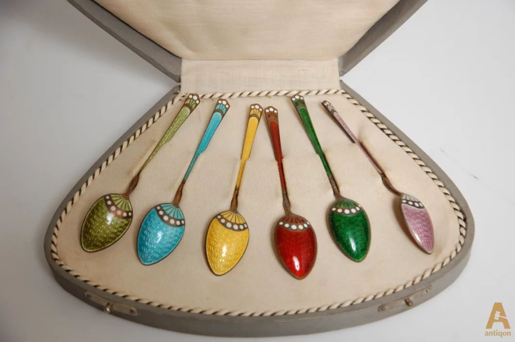 A set of silver spoons with enamel
