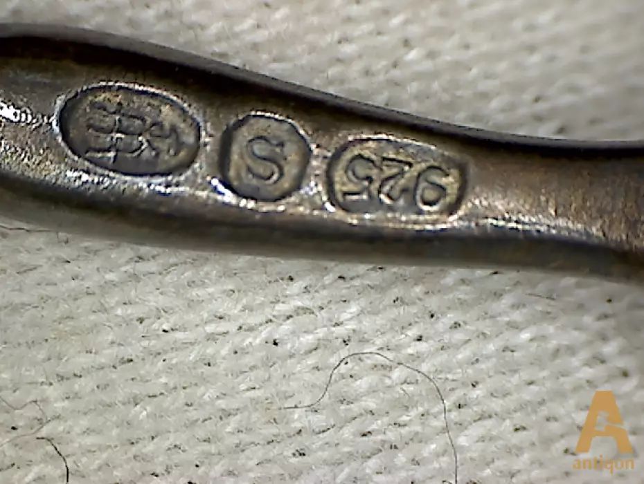 A set of silver spoons with enamel