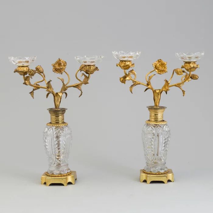 Paire de bougeoirs "Fleurs" en laiton dore et bronze sur colonnes de cristal. 