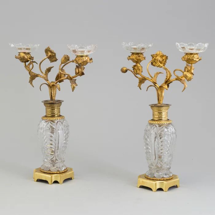 Paire de bougeoirs "Fleurs" en laiton dore et bronze sur colonnes de cristal. 