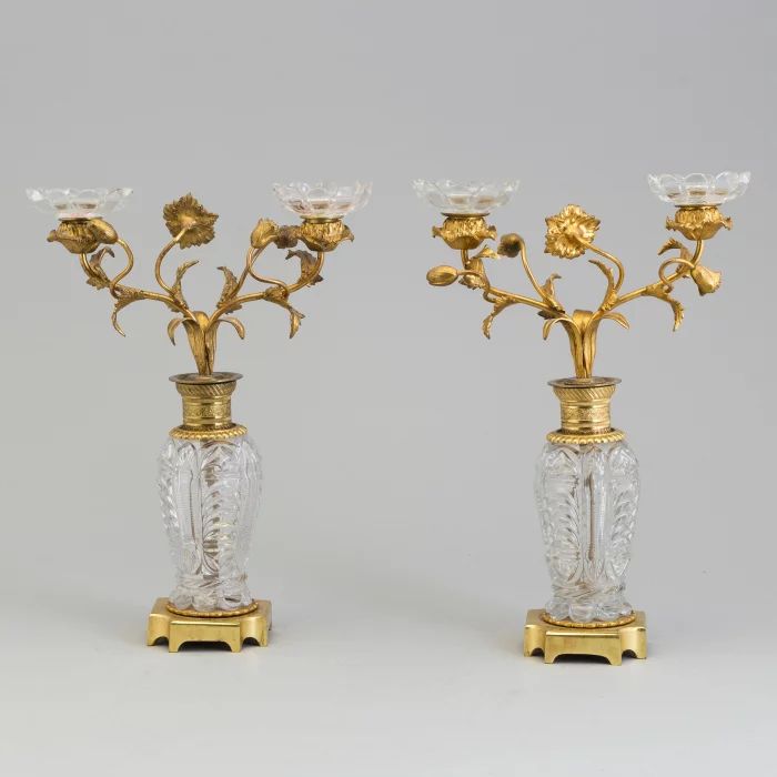 Paire de bougeoirs "Fleurs" en laiton dore et bronze sur colonnes de cristal. 