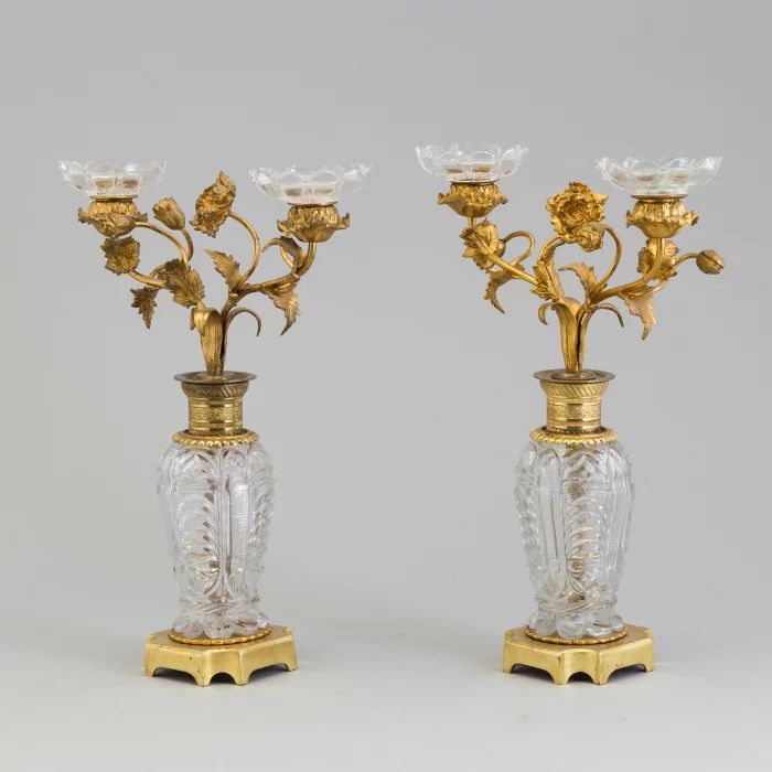 Paire de bougeoirs "Fleurs" en laiton dore et bronze sur colonnes de cristal. 