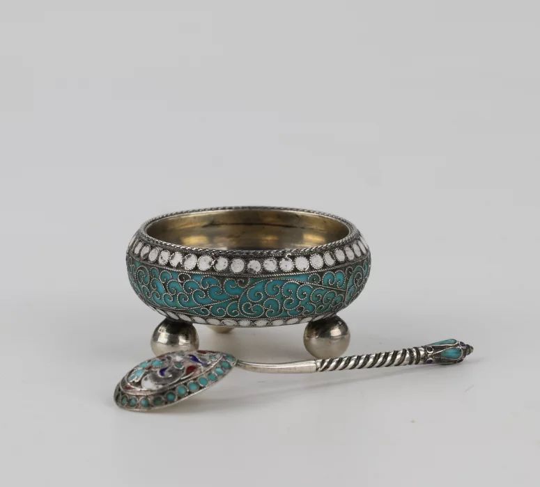 An elegant silver salt cellar with a spoon. 