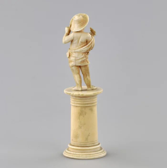 Carved ivory figurine of a boy with a bird 1800s.