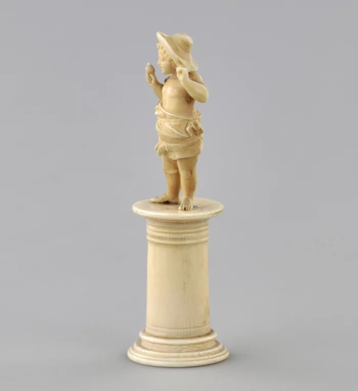 Carved ivory figurine of a boy with a bird 1800s.