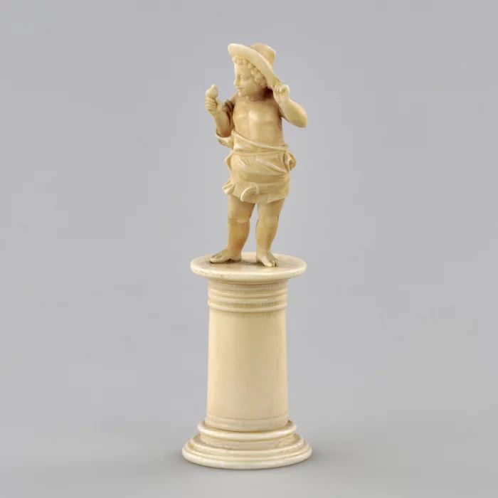 Carved ivory figurine of a boy with a bird 1800s.