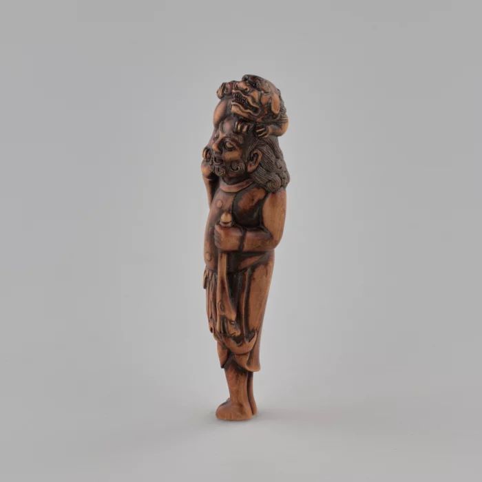 Netsuke en bois Voyageur avec un chien sur la tête style Tadakazu 1819 siècle.