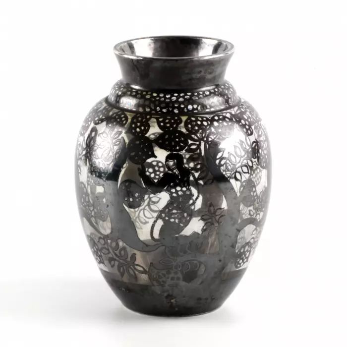 Decorative glass vase with cut-out silver decor. 