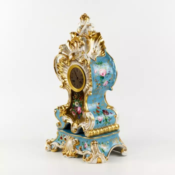 Une gracieuse horloge en porcelaine sur un socle neo-rococo. 