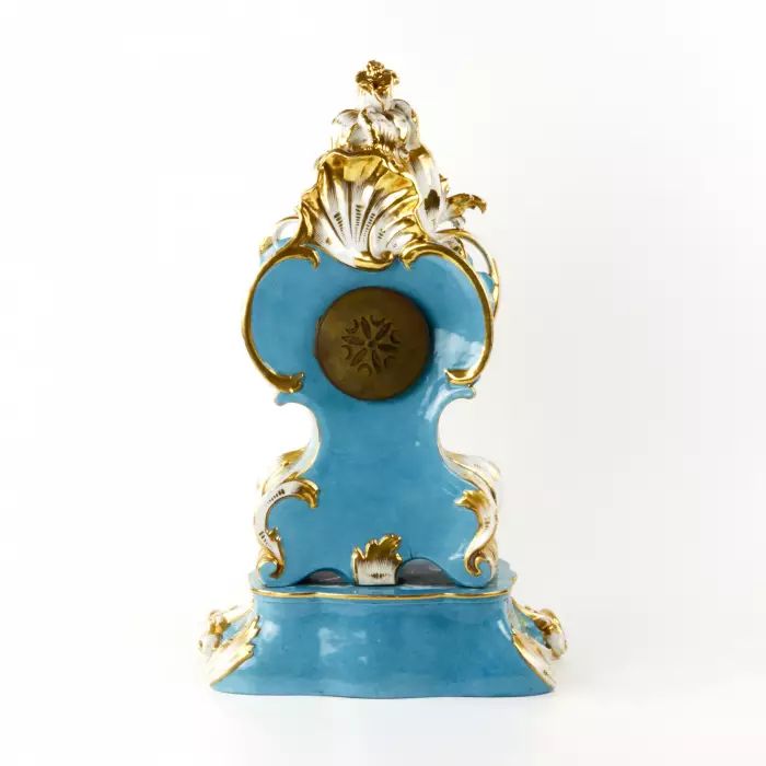 Une gracieuse horloge en porcelaine sur un socle neo-rococo. 