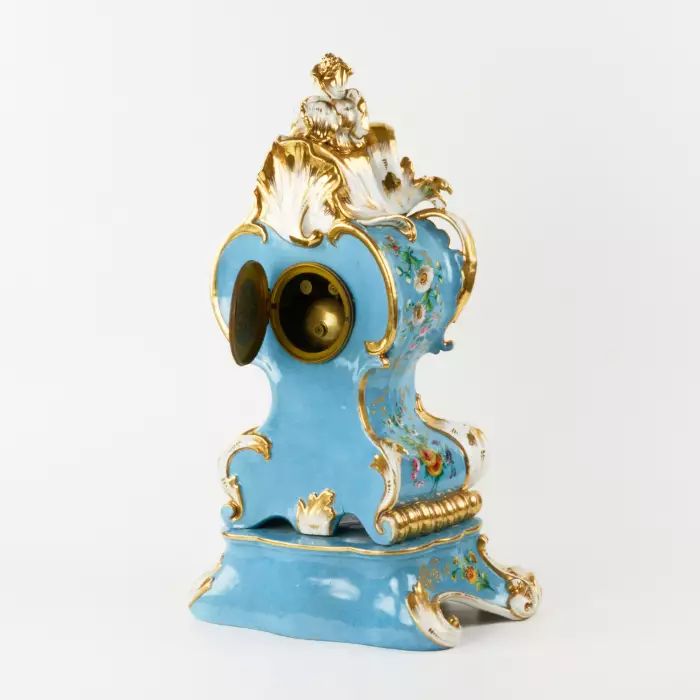 Une gracieuse horloge en porcelaine sur un socle neo-rococo. 