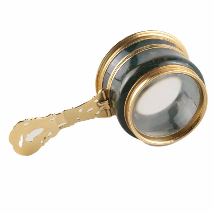 Magnifier in gold frame.