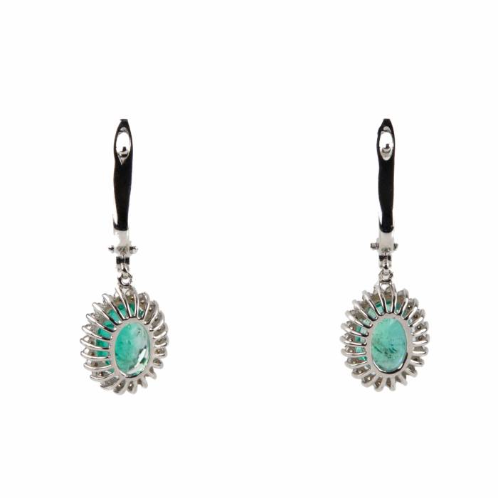 White gold earrings with green emeralds. 