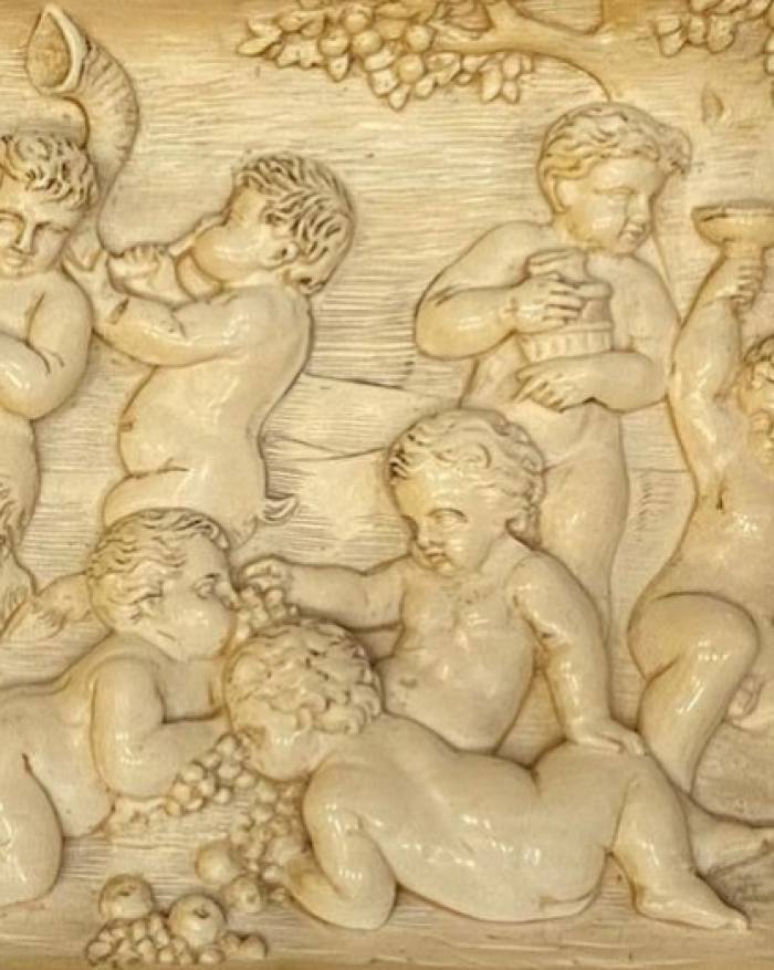 A carved bone panel depicting Putti playing. Germany 18th century