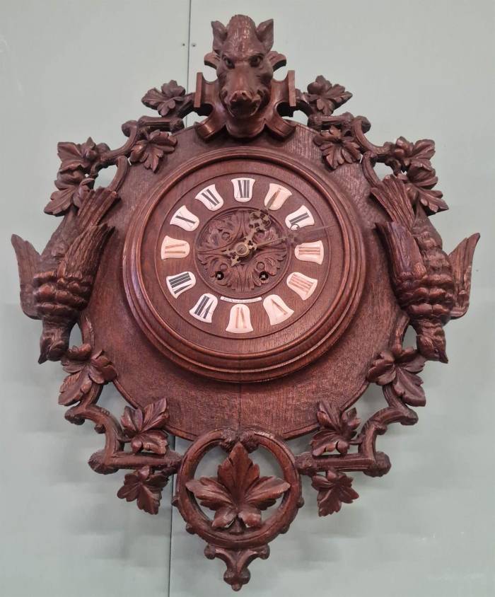 Mednieku stila sienas pulkstenis 