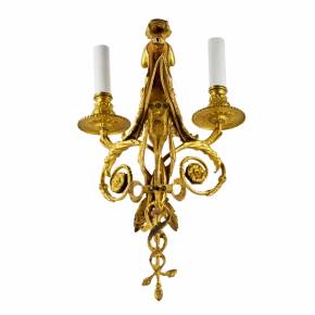 Four intricate gilded sconces with currency curls crowned with cherubs. 