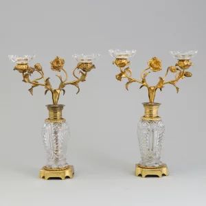 Paire de bougeoirs "Fleurs" en laiton dore et bronze sur colonnes de cristal. 