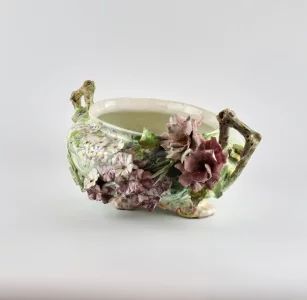 Liberty style faience pot with sprouting flowers.