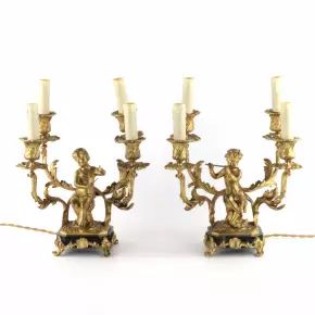 Lampes jumelées en bronze doré avec des amours jouant de la musique. 